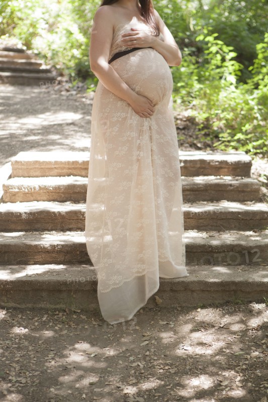 Pregnant Caucasian woman standing on hillside steps