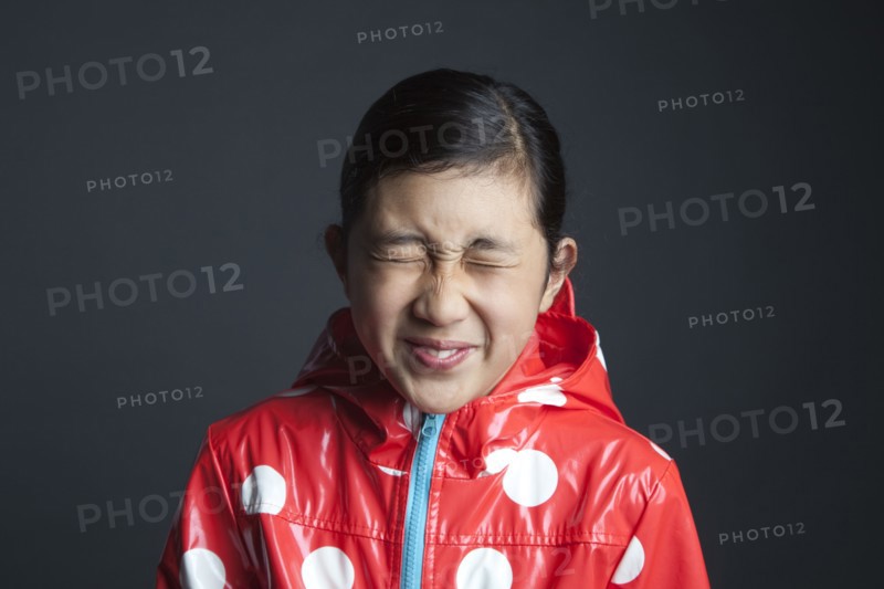 Blinking Asian girl wearing raincoat