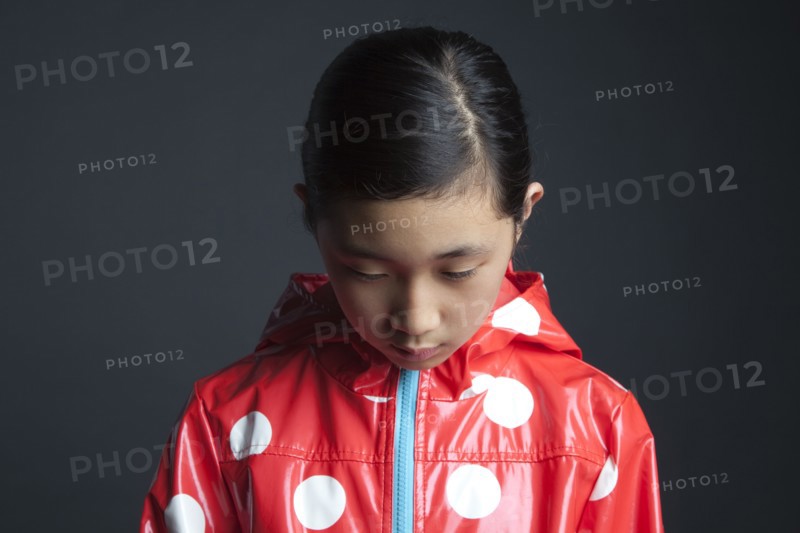 Sad Asian girl wearing raincoat