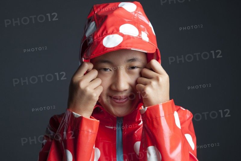 Smiling Asian girl wearing hooded raincoat