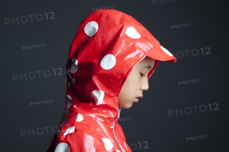 Disappointed Asian girl wearing hooded raincoat