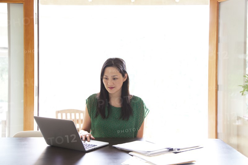 Korean woman paying bills on laptop