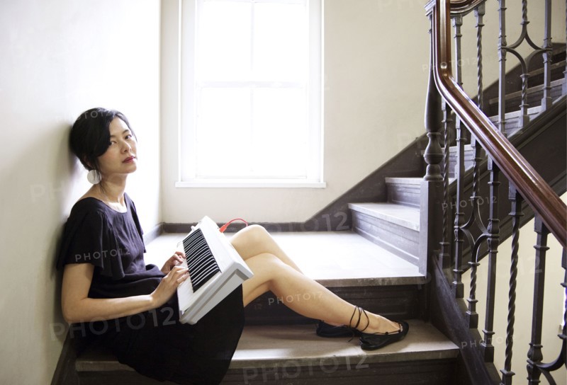 Taiwanese woman playing keyboard on staircase