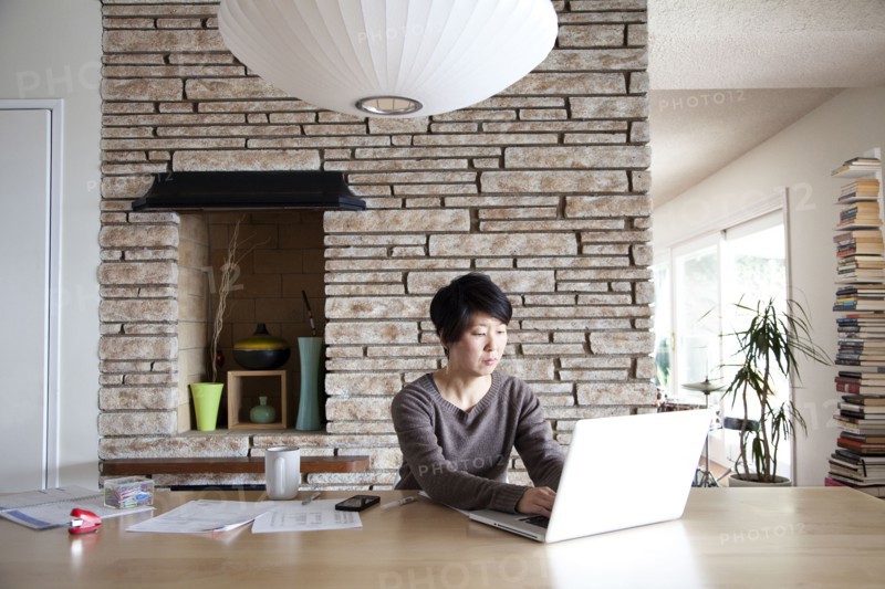 Japanese woman paying bills on laptop