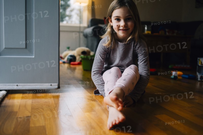 Smiling girl sitting on playroom floor
