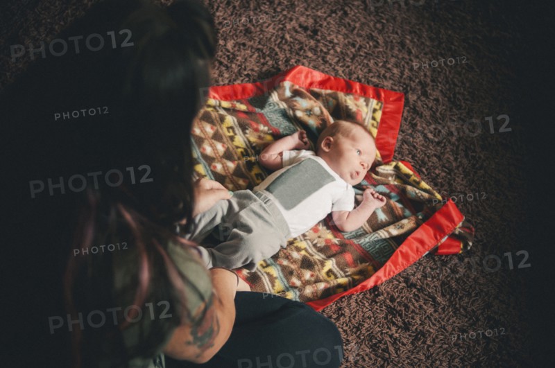 Mother playing with baby daughter on blanket