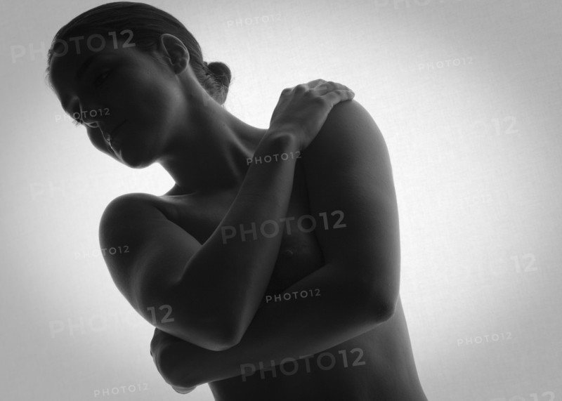 Nude woman covering her breasts