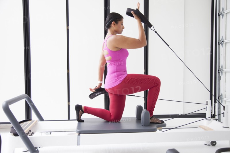 Asian woman using exercise machine in gymnasium