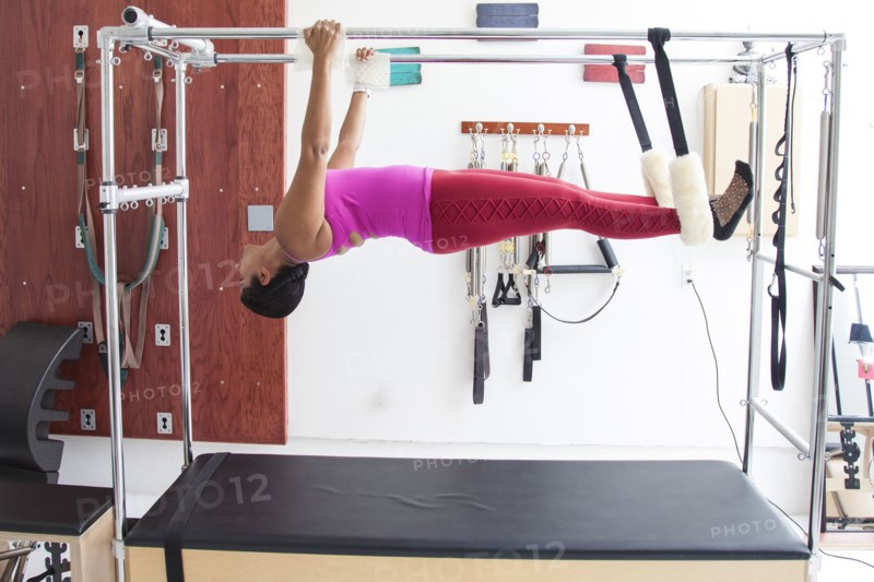 Asian woman using exercise machine in gymnasium
