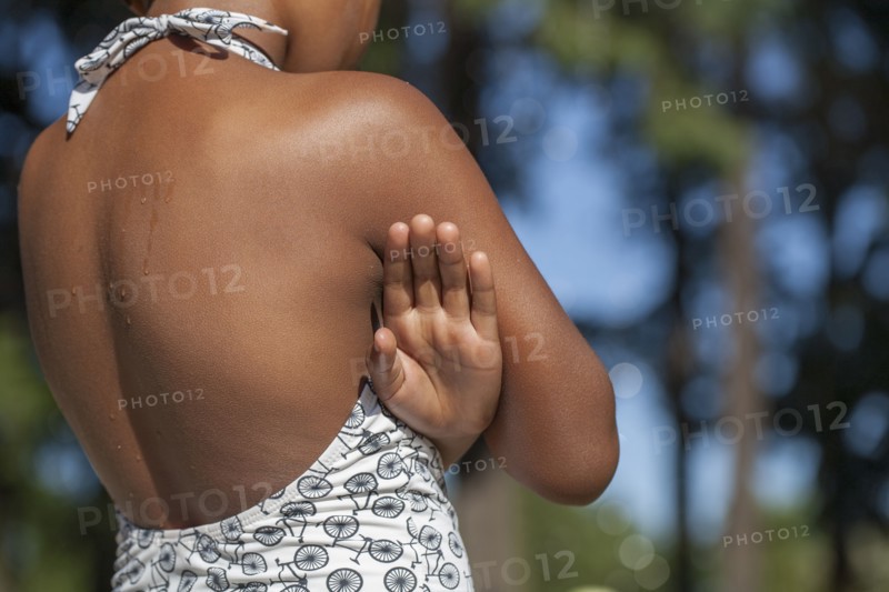 Rear view of girl wearing swimsuit near trees