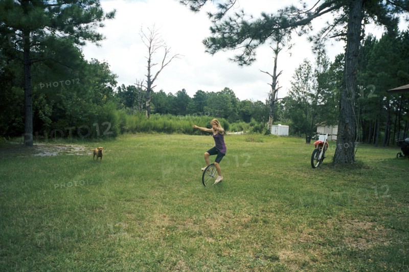 Girl playing on unicycle in field