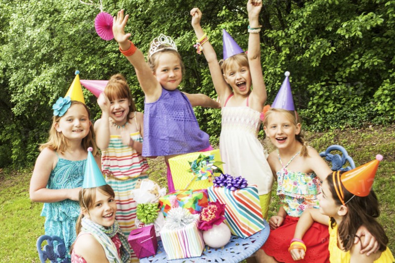 Girls cheering with gifts at birthday party