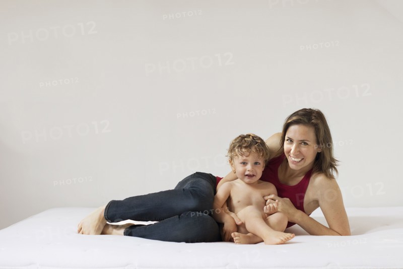Caucasian mother and son laying on bed
