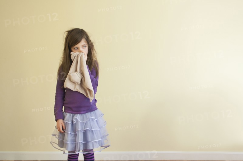 Sick Caucasian girl wiping nose