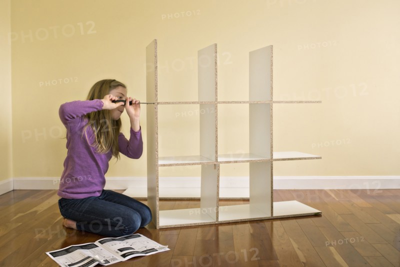 Caucasian girl building bookcase
