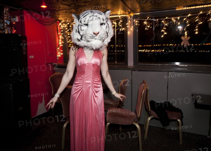 Woman wearing evening gown and tiger mask in bar
