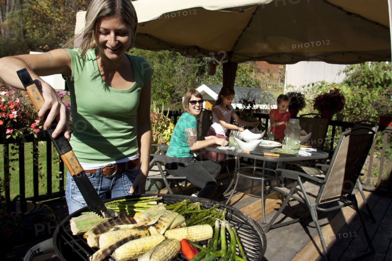 Woman grilling vegetables on patio