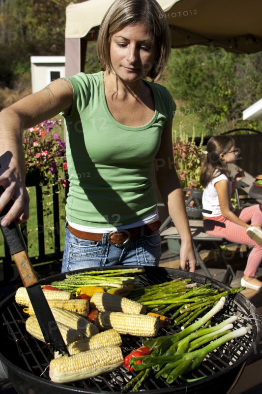 Woman grilling vegetables on patio