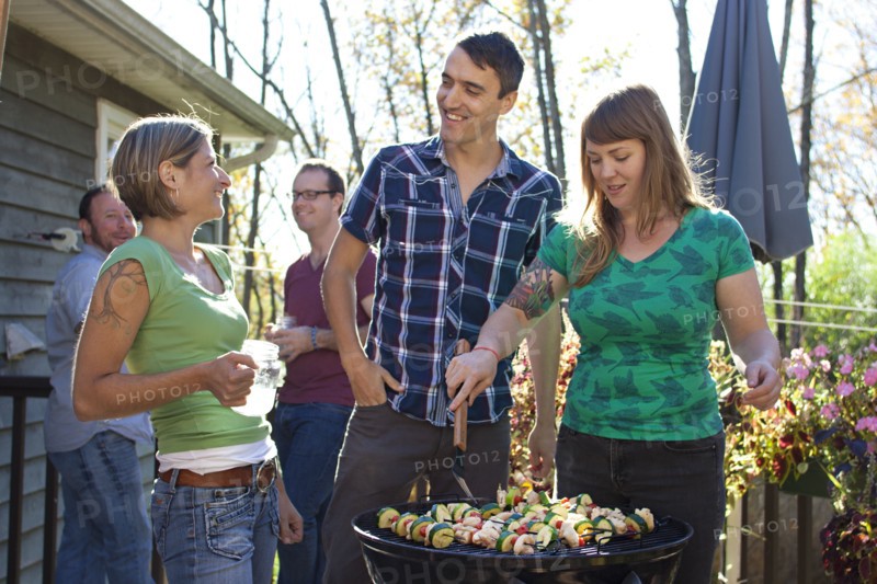 Friends grilling vegetables in backyard