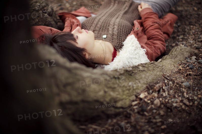 Caucasian woman laying under tree