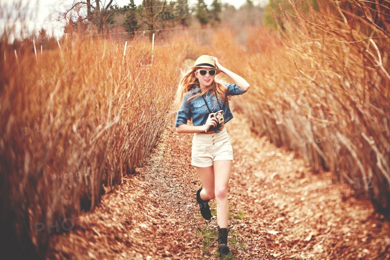 Caucasian woman carrying instant camera on dirt path