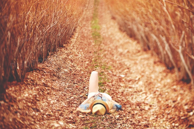 Caucasian woman laying on dirt path