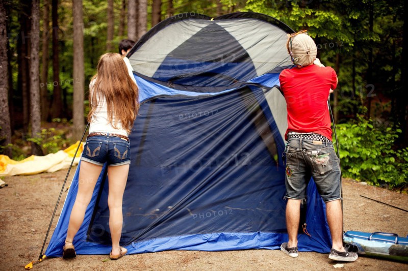 Couple setting up tent at campsite
