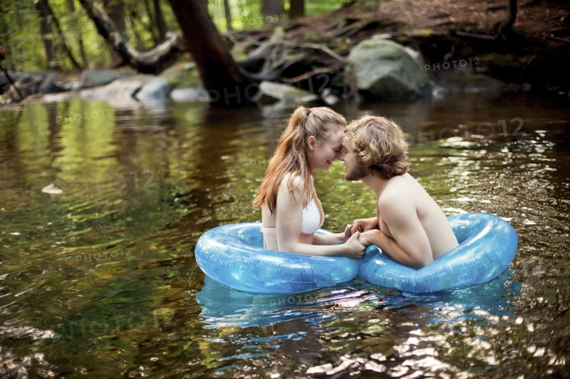 Couple holding hands in forest river