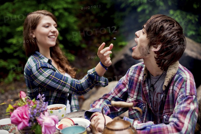 Couple feeding each other in forest
