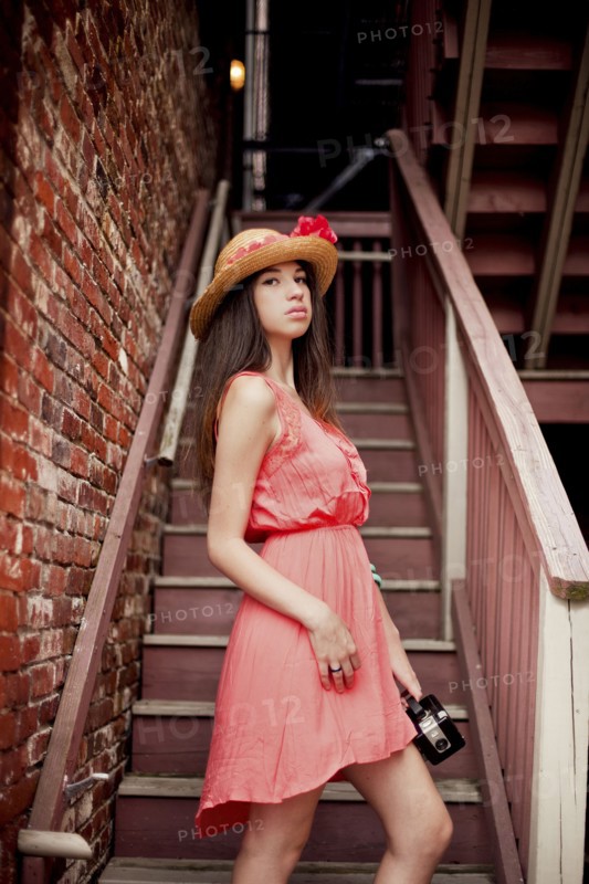 Girl wearing straw hat on staircase