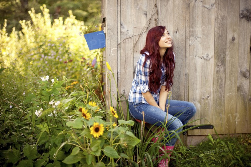 Gardener sitting near wooden shed in backyard