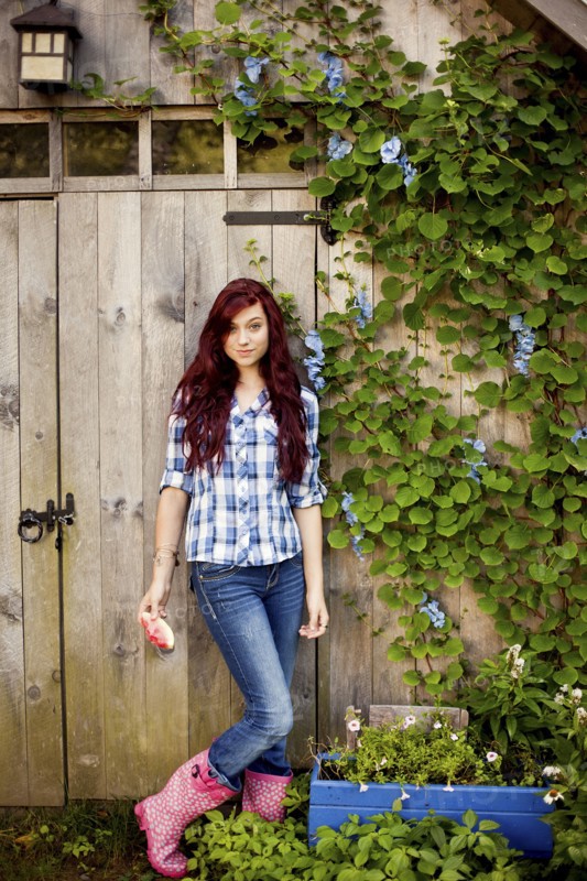 Gardener standing near wooden shed in backyard
