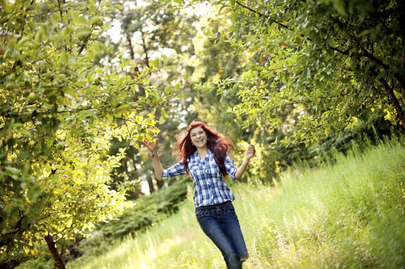Girl walking in tall grass in rural field