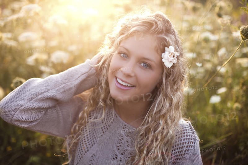 Woman sitting in tall flowers