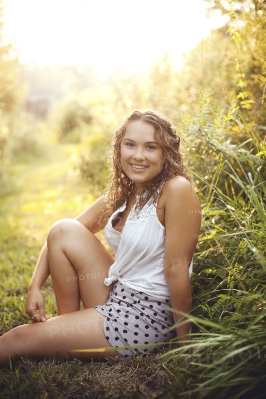 Smiling woman sitting in rural field