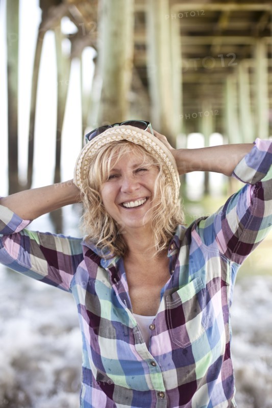 Caucasian woman standing under boardwalk on beach
