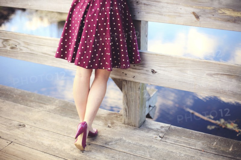 Woman standing on wooden dock over still lake