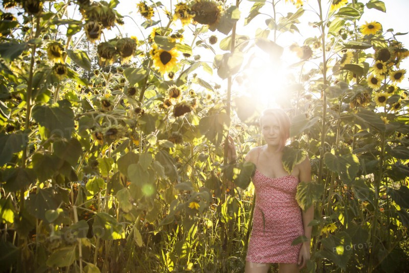 Caucasian woman standing under sunflowers in garden