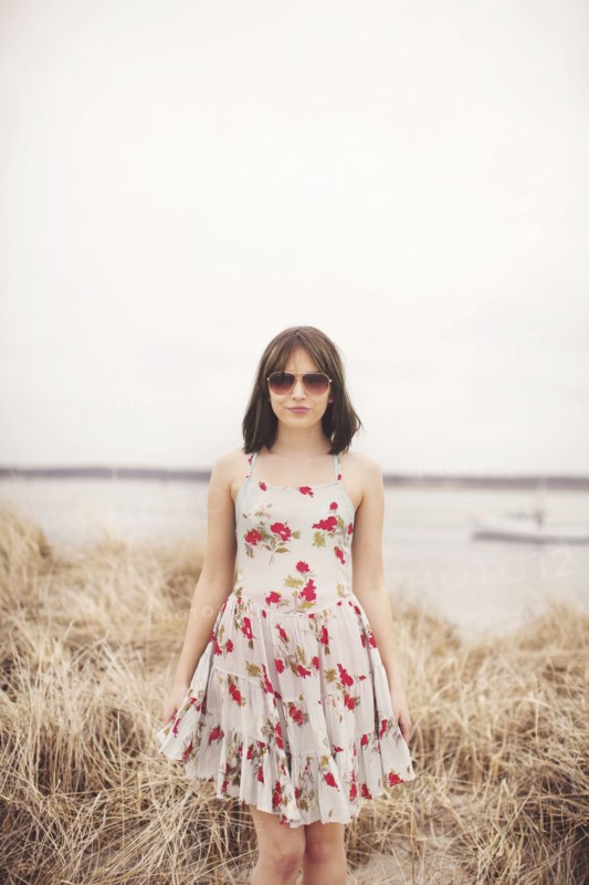 Caucasian woman standing in beach grass