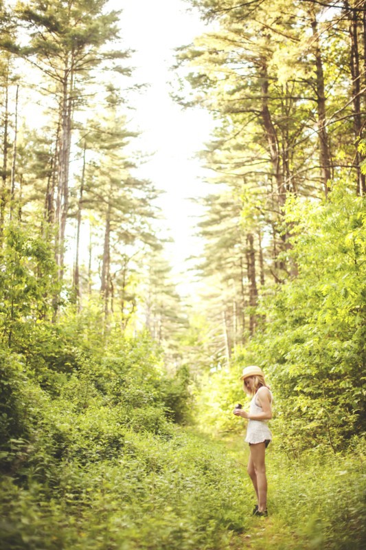 Caucasian woman walking on grass path in forest