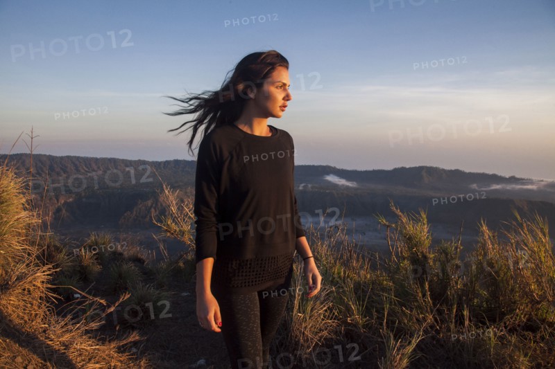 Woman admiring rural landscape from mountain path