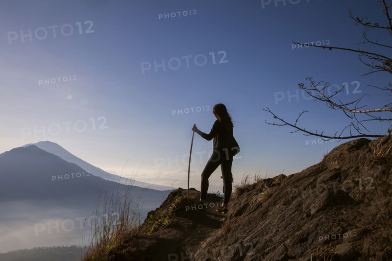 Woman admiring rural landscape from mountain path