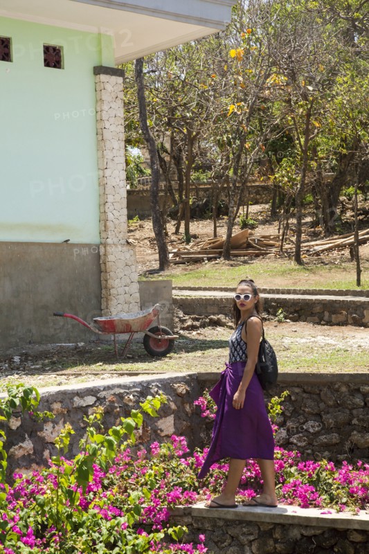 Woman walking by rock wall in garden