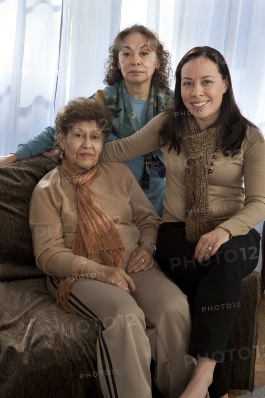Three generations of women smiling on sofa