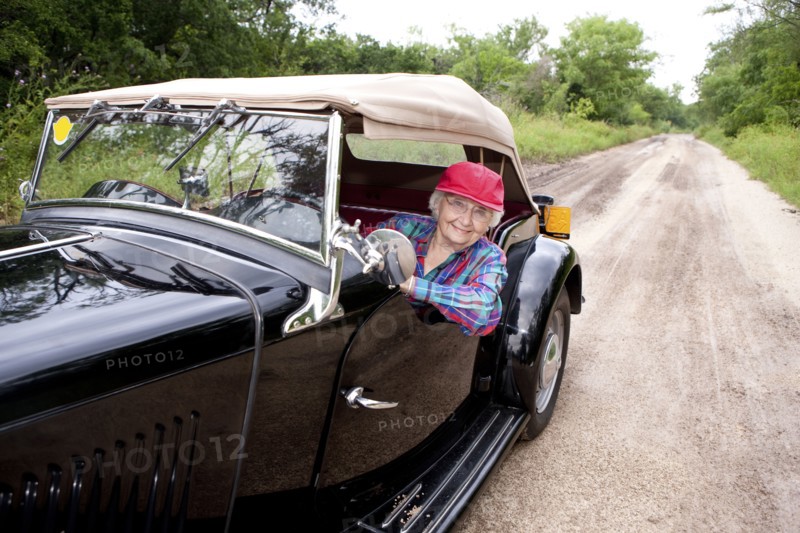 Older Caucasian woman driving convertible on rural road
