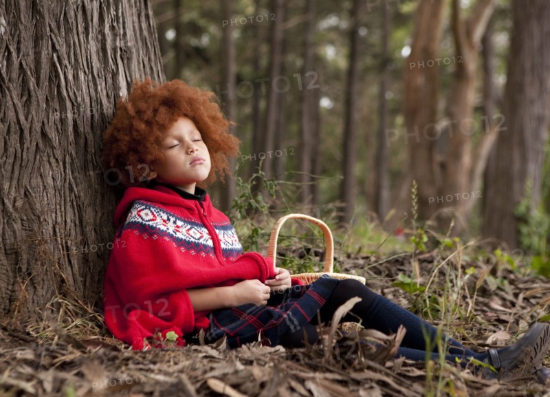 Girl napping under tree in park