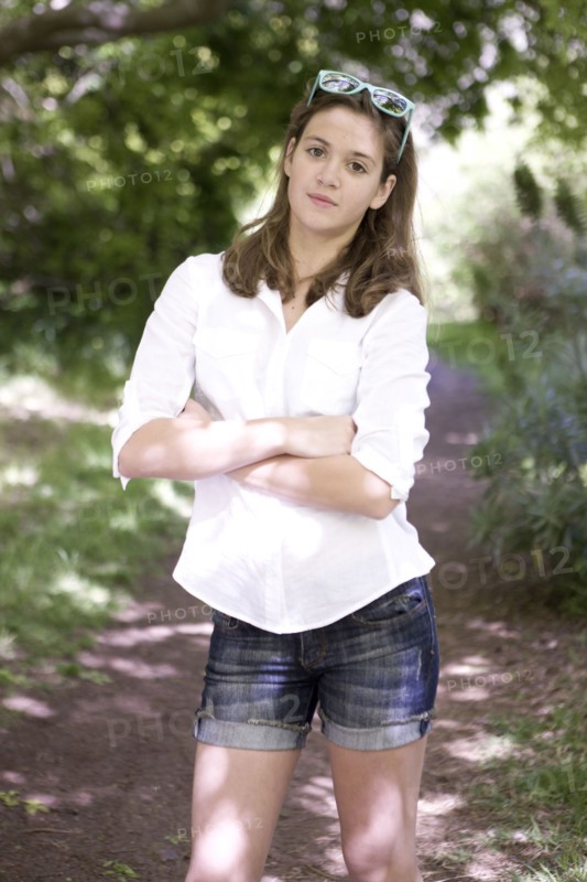 Caucasian teenage girl standing on dirt path