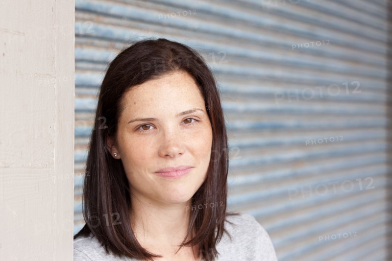 Close up of smiling woman standing by garage door