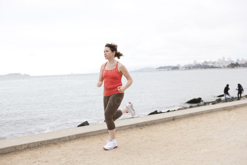 Caucasian woman running on waterfront