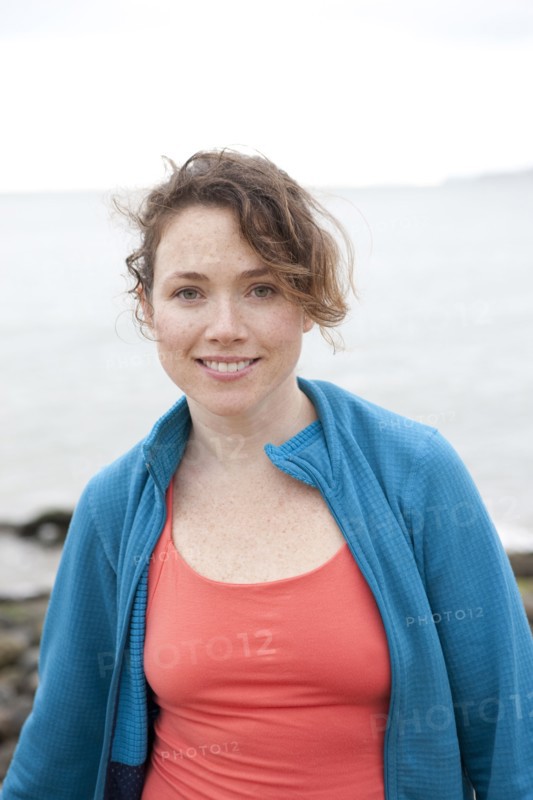 Caucasian woman smiling on rocky beach